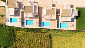 A modern multi-story hotel with a rooftop pool area, multiple swimming pools, and a landscaped garden. - Vista Mare Maxima Heated Pool (Georgioupoli)