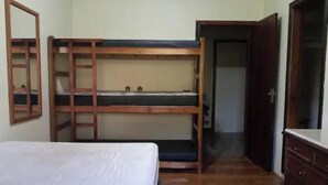 A room with a bunk bed, a wardrobe, and a door leading to another room. - Beautiful country property surrounded by nature in Jarinú (Jarinu)