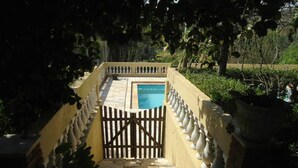 A gated pool area with a stone pathway leading to a pool, surrounded by a low wall with balustrades. - Beautiful country property surrounded by nature in Jarinú (Jarinu)