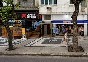 A street view with a restaurant named 'JAPA DA QUITANDA' and a clothing store named 'citvcol'. - Copacabana: quiet apartment near the beach and metro (RJ)