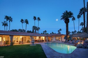 A resort with a swimming pool, palm trees, and a thatched-roof structure. - Maison du Soleil (Palm Springs)