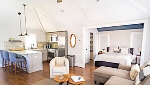 A modern apartment with a kitchen, dining area, and a living room with a sofa and a coffee table.