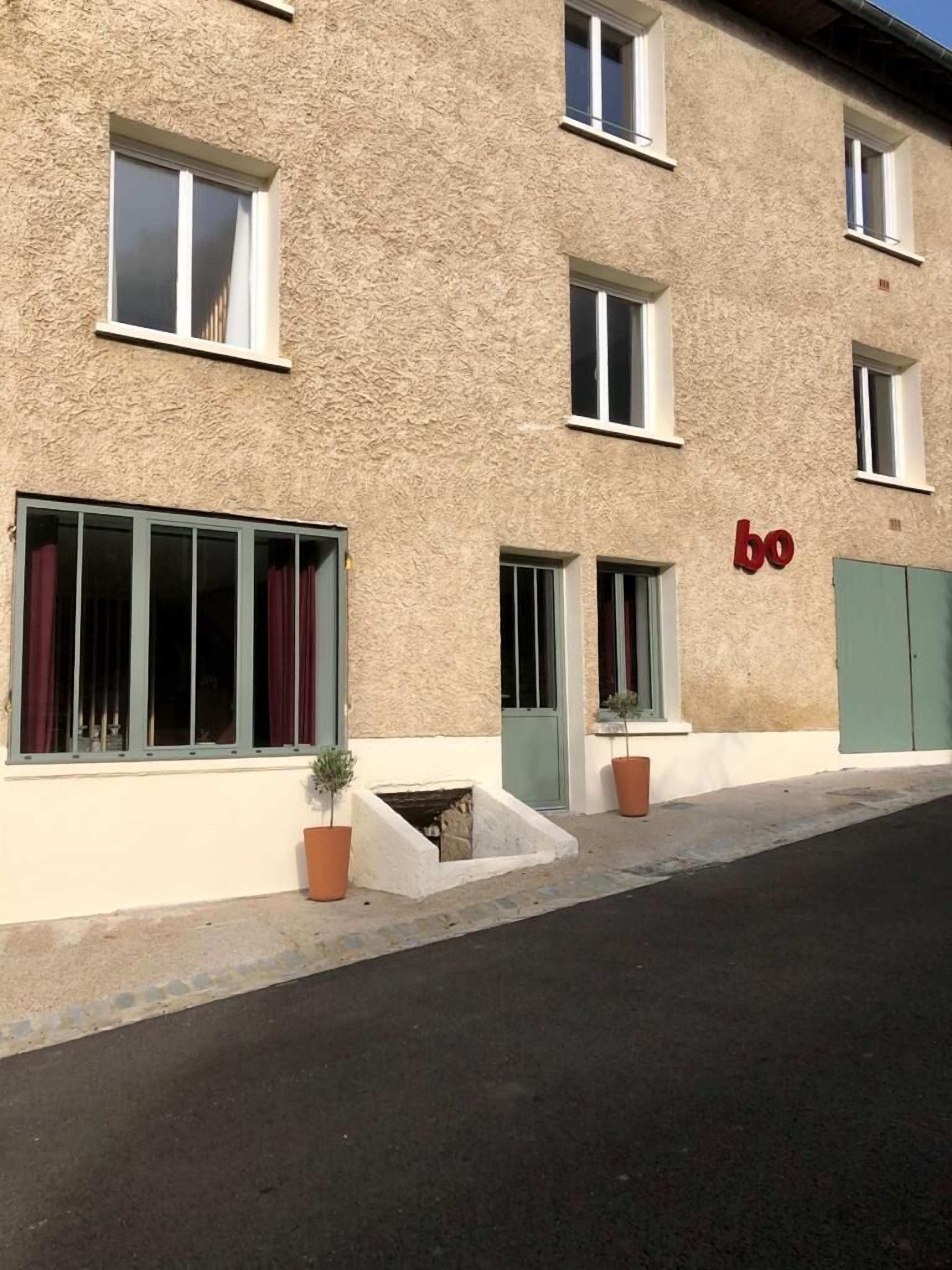 A building with a textured facade, multiple windows, and a prominent 'bo' sign.