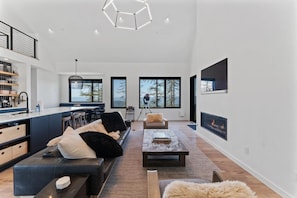 En modern inredning med ett kök, en matplats och ett vardagsrum med en öppen spis.