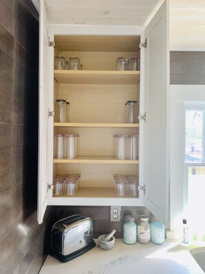 A kitchen with a built-in cabinet, a toaster, a mortar and pestle, and jars labeled 'Tea Bags' and 'Sugar'. - Pet Friendly 2/1.5 in the Heart of Historic Pensacola (Pensacola)