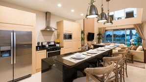 A modern kitchen with a central island, stainless steel appliances, and a dining area with a sofa and chairs. - Just 3.5m to Disney/Lovely Home/No Resort fee/Parking/Wi-Fi/Free Club House Use (Kissimmee)