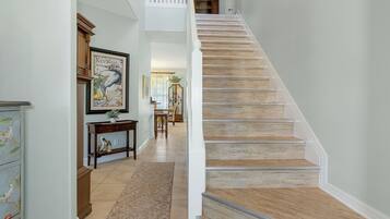 A staircase with wooden steps and white railings, leading to a second floor.