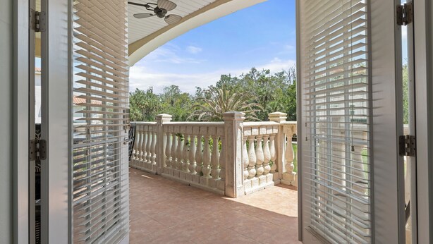 An open balcony with a view of a garden and a building in the background. - Waterfront! Docks available for rent and extra parking lot and ice machine (Homosassa)