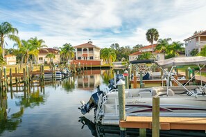 Boats docked at the marina, surrounded by residential buildings with balconies and palm trees.