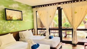 A hotel room with two beds, a green wall with a floral mural, and large windows with curtains. - Baan Duangkaew (Hua Hin)