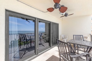 Enjoy the ocean view from this balcony with a table and chairs, perfect for relaxing.