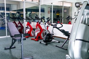 A gym with stationary bikes, a treadmill, and a bench. - Hotel Mirage (La Piedad)