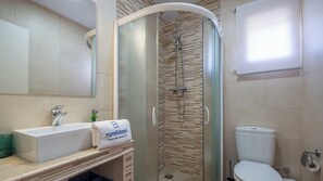 Une salle de bain avec une douche, des toilettes et un lavabo.