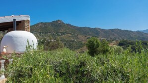 Un paysage rural avec une structure sphérique blanche, qui pourrait être un réservoir d’eau, entourée de verdure et avec des collines en arrière-plan.