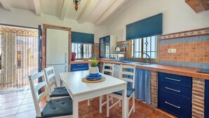 Une cuisine équipée d’une table à manger, de chaises, d’un évier et d’une fenêtre.