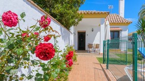 A white building with a tiled roof, a brick pathway, and a green gate. - Casas Villanueva - Casa 2 Conil de la Frontera by Ruralidays (Cádiz)