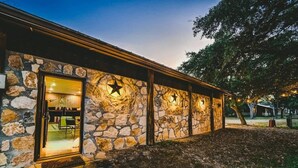 Un edificio de piedra con puerta de cristal, luces con forma de estrella y fachada de piedra.