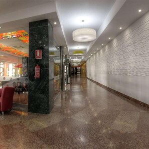 A hotel corridor with a marble column, a fire extinguisher, and a patterned wall. - Hotel Spa Entremares (Cartagena)