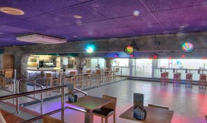 An indoor space with tables and chairs, a counter area, and large windows. - Hotel Spa Entremares (Cartagena)