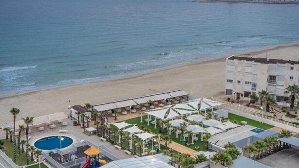 A beachfront hotel with a pool, outdoor seating, and a view of the sea. - Hotel Spa Entremares (Cartagena)
