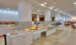 A buffet area with multiple food stations, seating arrangements, and a tiled floor. - Hotel Spa Entremares (Cartagena)