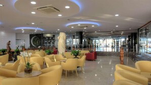 A modern lobby with yellow chairs, a central pillar, and a statue. - Hotel Spa Entremares (Cartagena)