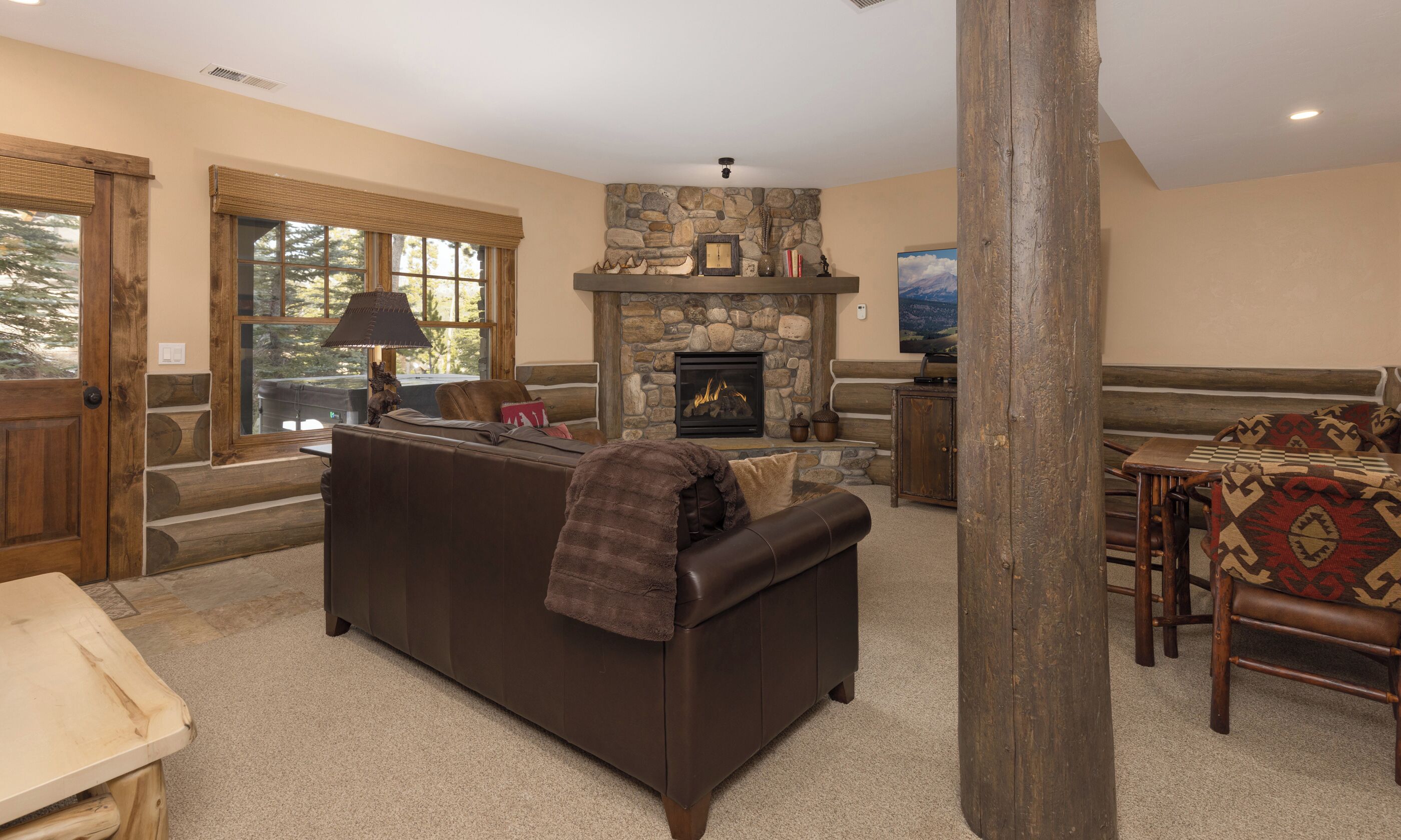 Cozy up in this inviting living space with plush leather seating and a crackling stone fireplace, perfect for mountain evenings together.