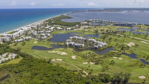 Un parcours de golf comportant de nombreux obstacles d’eau, une plage et un port de plaisance.