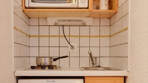 A compact kitchenette with a microwave, stove, and refrigerator. - Studio au Pied des Pistes! Local à Skis (Les Deux Alpes (Isère))