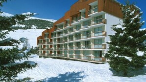 A multi-story hotel with balconies, set against a snowy mountain backdrop. - Studio au Pied des Pistes! Local à Skis (Les Deux Alpes (Isère))