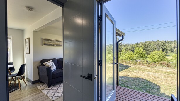 A modern interior with a sliding glass door leading to a deck. - ► Modern Tiny House ◄ Big Personality, AC & Views! (Tukwila)