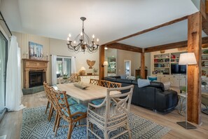 A spacious living room with a fireplace, dining area, and a cozy seating area. - Perfect Beach House Steps to Ocean! Sleeps 10! Amenity access included! Pet Friendly! (Seabrook Island)