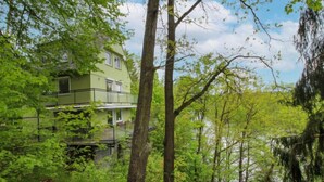 A two-story building surrounded by dense forest.