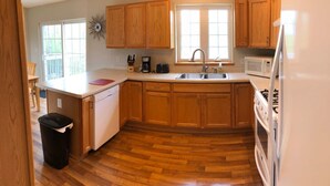 A kitchen with wooden cabinets, a stainless steel sink, a microwave, and a dishwasher.