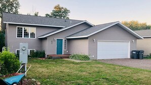 A two-story house with a garage, a front door, and a small front yard.