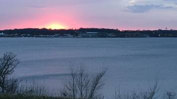 A sunset over a body of water with buildings in the background.