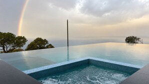 An infinity pool with a view of the sea and a rainbow. - All The Views - Ocean & Bush with Heated Infinity Lap and Play Pool (Otford)