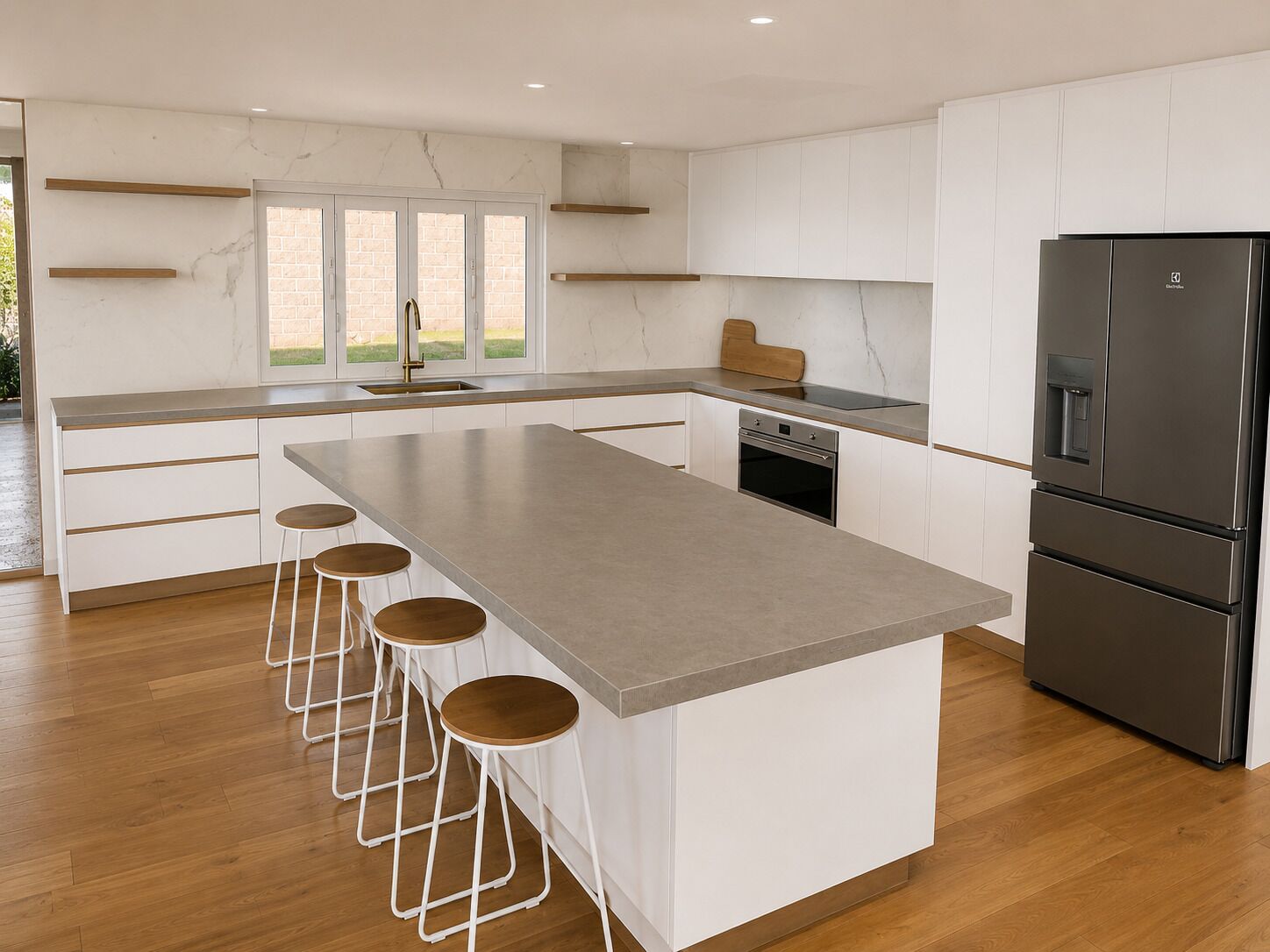 A modern kitchen with a central island, bar stools, a built-in oven, and a stainless steel refrigerator.