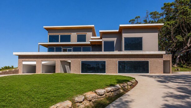 A modern two-story house with a flat roof, large windows, and a well-maintained lawn. - All The Views - Ocean & Bush with Heated Infinity Lap and Play Pool (Otford)