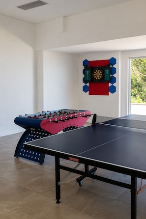 A room with a foosball table, a ping pong table, and a dartboard. - All The Views - Ocean & Bush with Heated Infinity Lap and Play Pool (Otford)
