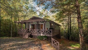 A cabin with a porch, a covered entrance, and a number '3609' on the side. - Shady Creek Cabin in Connestee Falls with stream (Brevard)