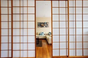 A room with a sliding shoji screen door, a sofa, and a stone artwork on the wall. - Bella Casa Sorrento (Sorrento)