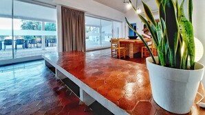 A spacious living area with a large window, a dining area, and a potted plant. - An architectural gem in Las Tablas de Daimiel (Daimiel)