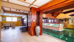 A spa area with a wooden reception desk, a large vase, and a tiled pool. - Anyaburi Private Pool Villa (Chalong)