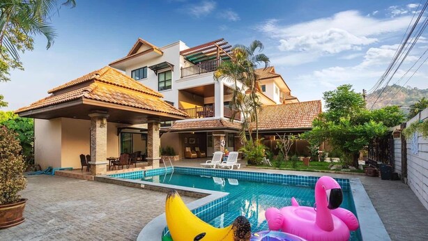 A two-story house with a swimming pool, outdoor furniture, and a balcony. - Anyaburi Private Pool Villa (Chalong)