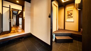 Un interior japonés tradicional con suelo de tatami, puertas correderas y un banco de madera.