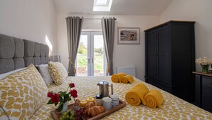 A bedroom with a bed, a breakfast tray, and a view of the outdoors.