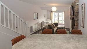 Une cuisine moderne dotée d’un grand îlot central, de meubles de couleur beige et d’un mur d’accent en pierre.