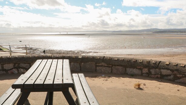 A beachside view with a wooden bench and a stone wall. - Casalmare (Exmouth)