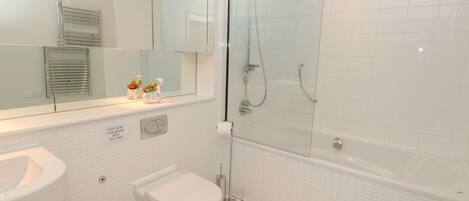 A modern bathroom with a glass-enclosed shower, a white sink, and a toilet.